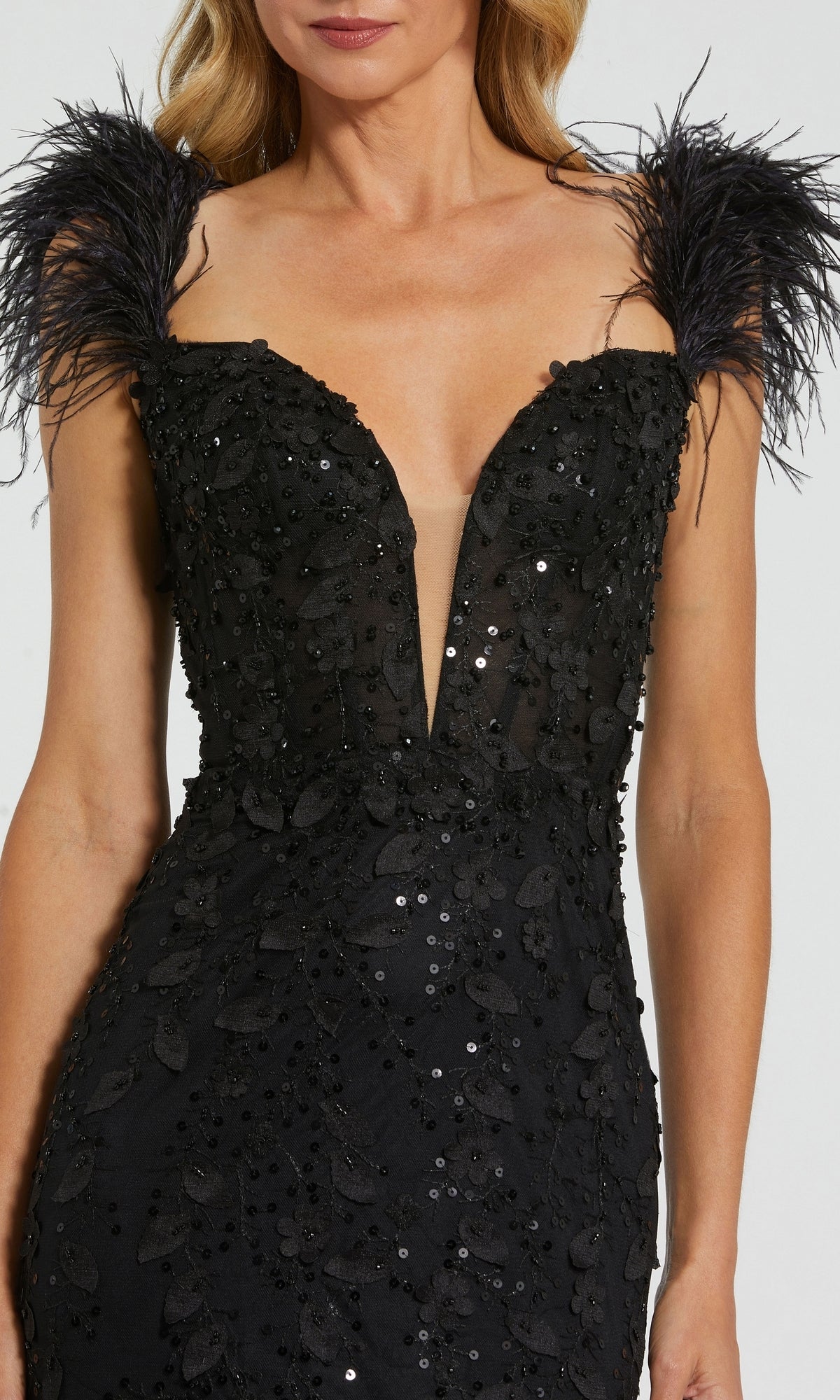 A woman in the Long Formal Dress 20889 by Mac Duggal: black fitted gown with a v-neckline, sequin embellishments, and striking feather shoulder straps.